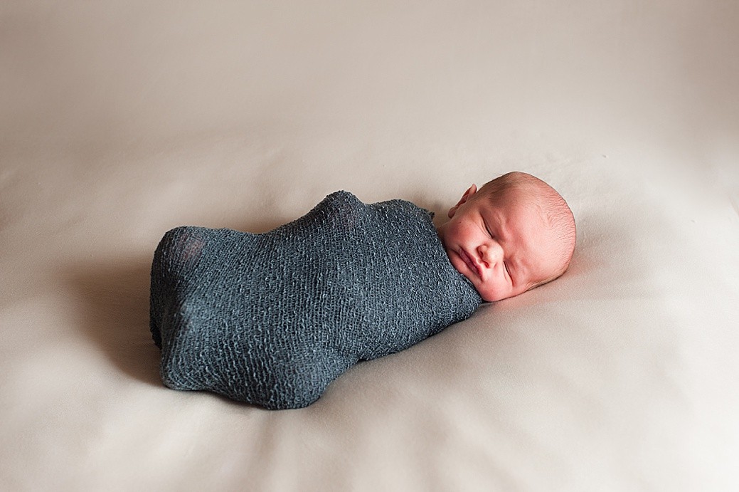 Newborn baby in blue wrap